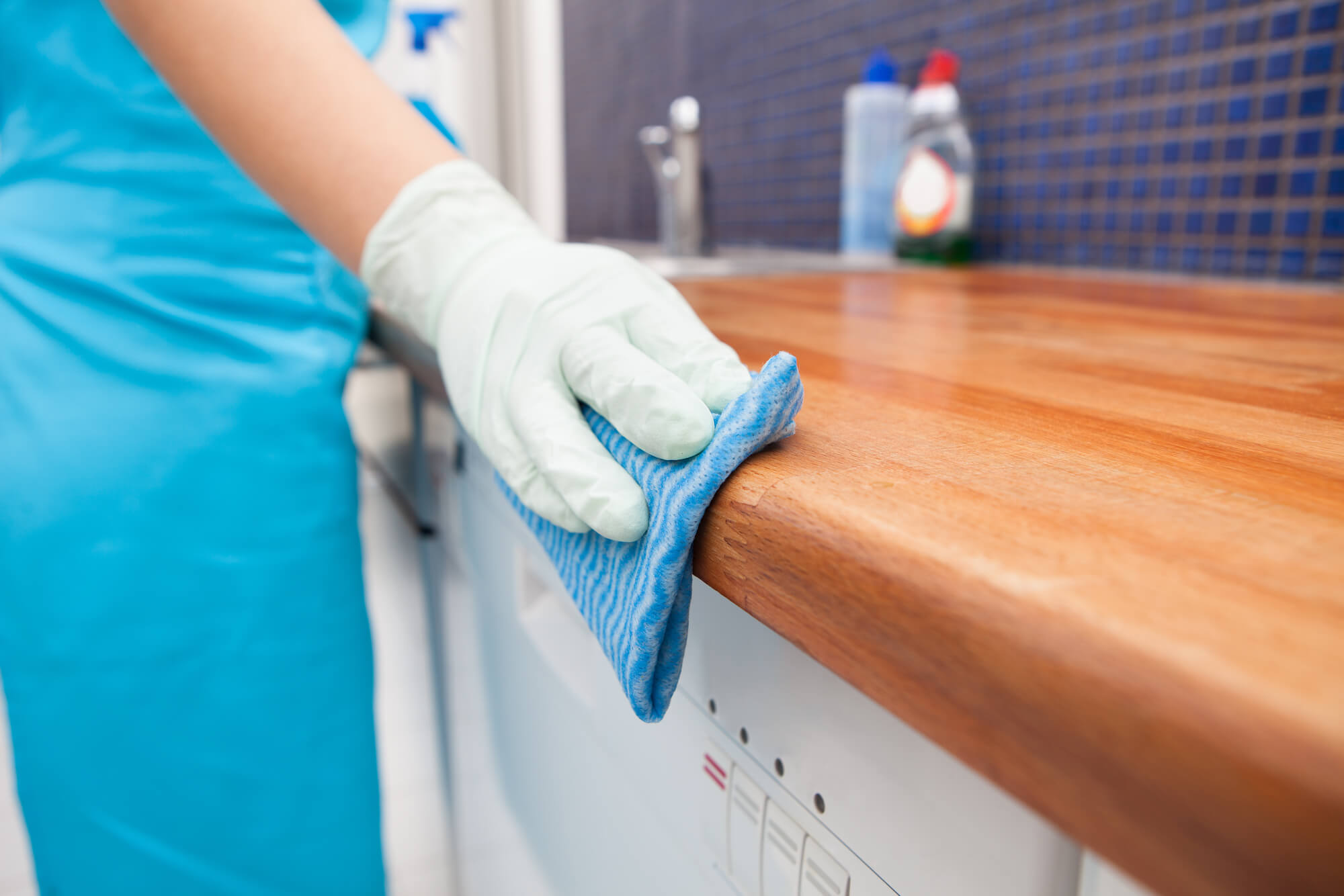 Woman Cleaning Kitchen Countertop